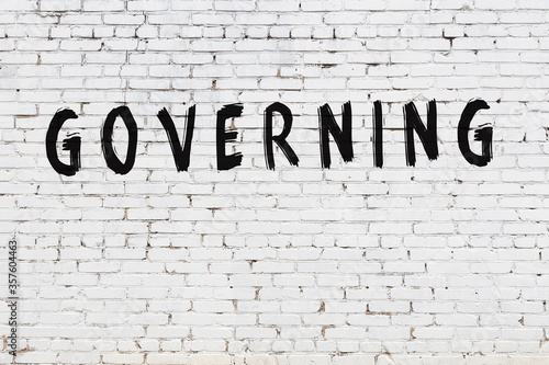 White wall with black paint inscription governing on it