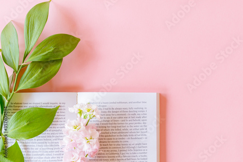 Top view of open book and Pink Matthiola incana or Mathilda Lavender with ruscus twig on pastel pink background with copy space. photo