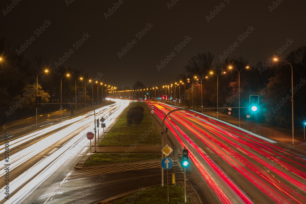Car moving on highway against dark night, photograph is taken with long exposure. 