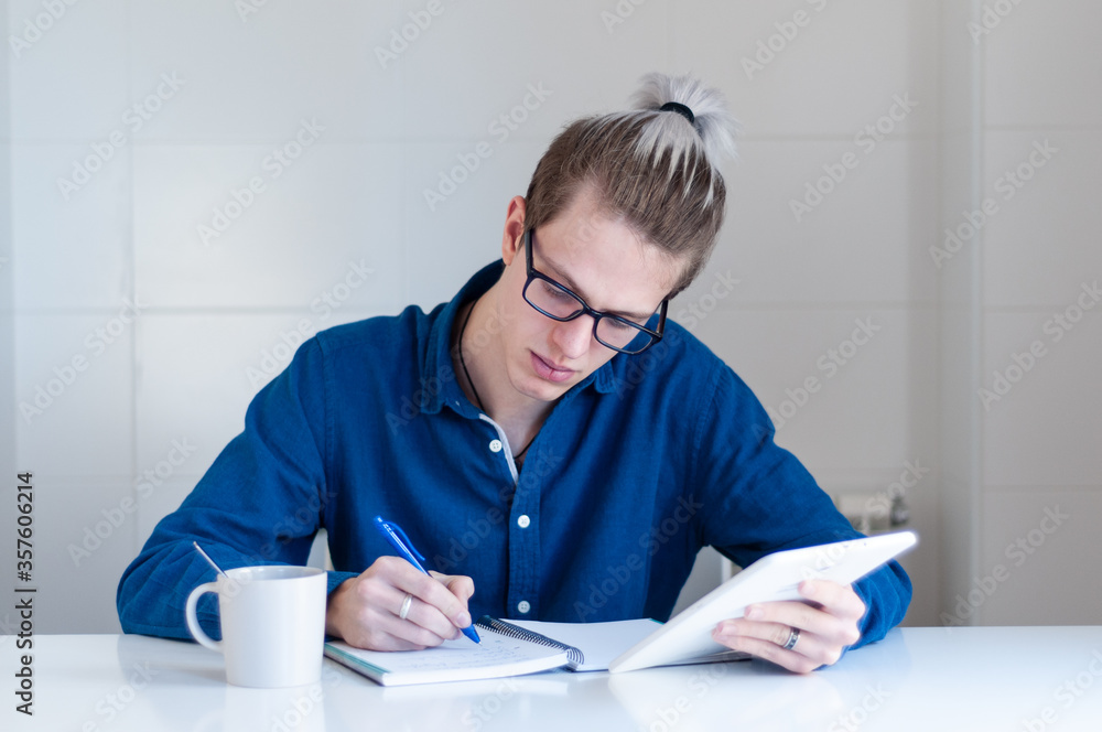 Portrait of young blonde adult with glasses working at home. Portrait of young blonde adult with glasses working at home.