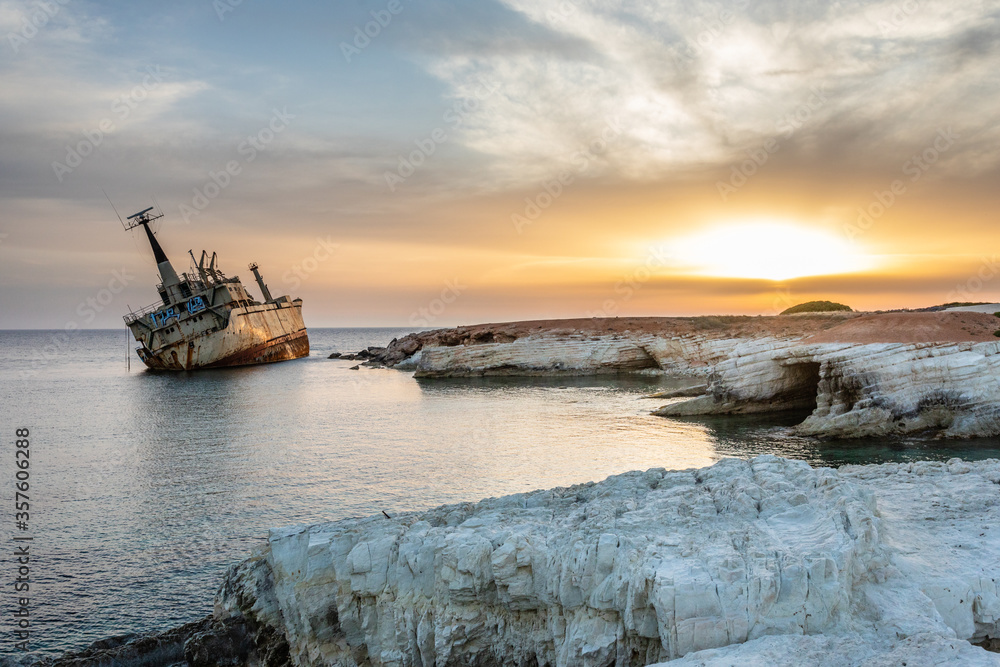 Obraz premium Abandoned rusty ship stranded ashore in the sunset rays at Peyia village, Paphos