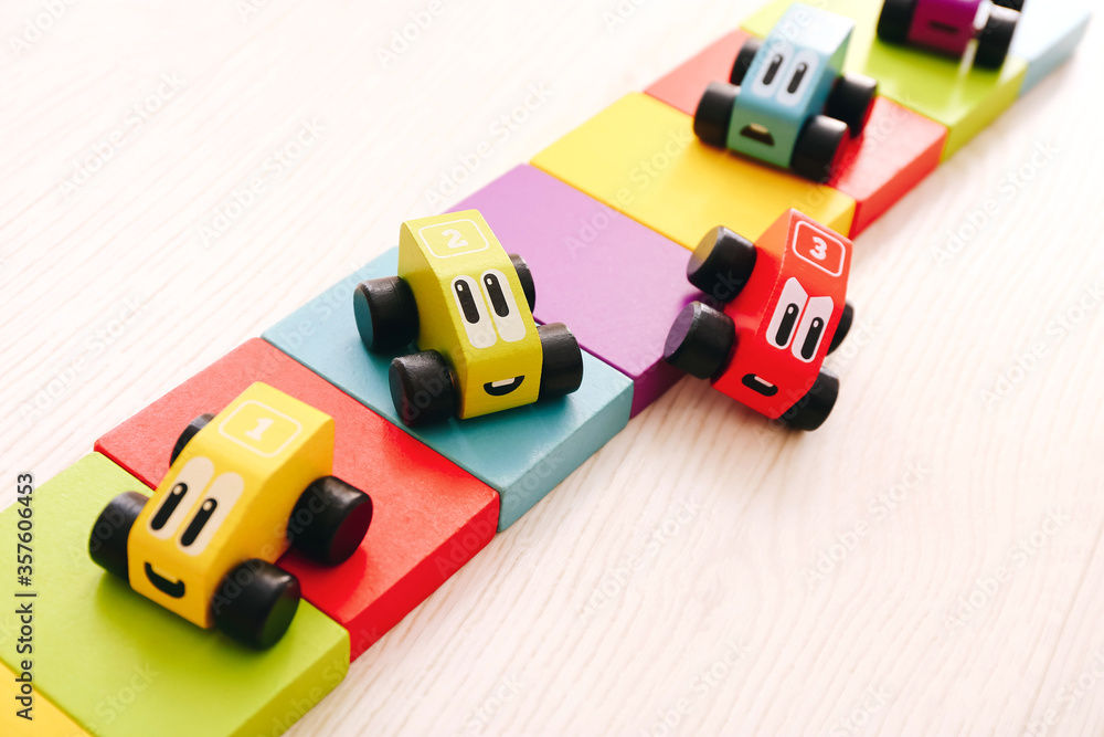 Obraz premium Educational toys for kids. Colorful wooden cars with numbers on floor background