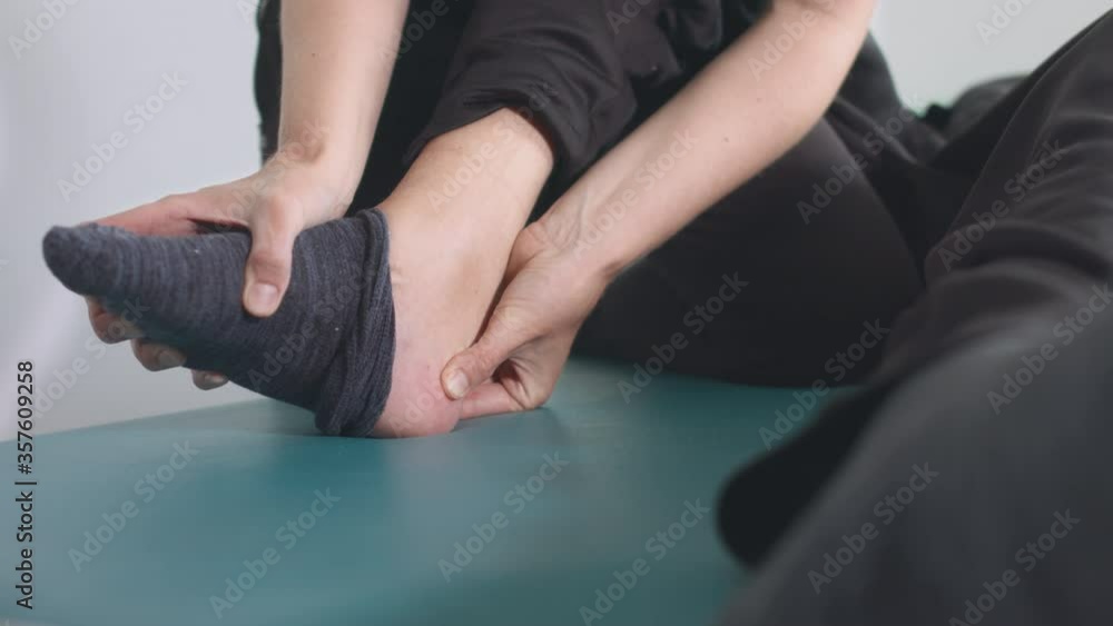 Closeup of physiotherapist exercising with disabled person on a therapy table. Closeup of physiotherapist exercising with disabled person on a therapy table.