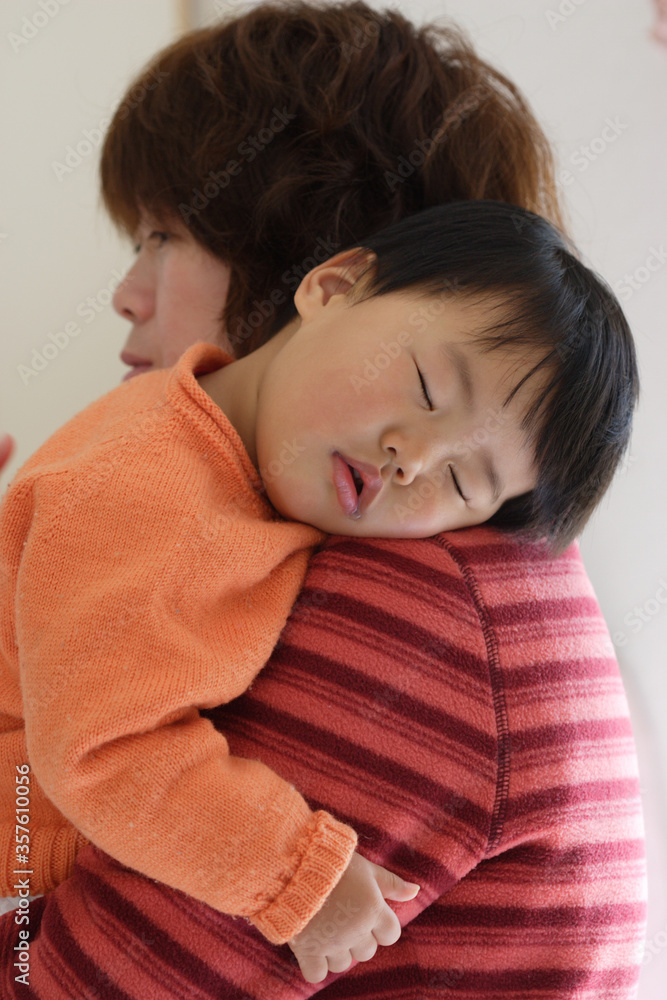 母親の肩に寝ている可愛い赤ちゃん 母親の肩に寝ている可愛い赤ちゃん