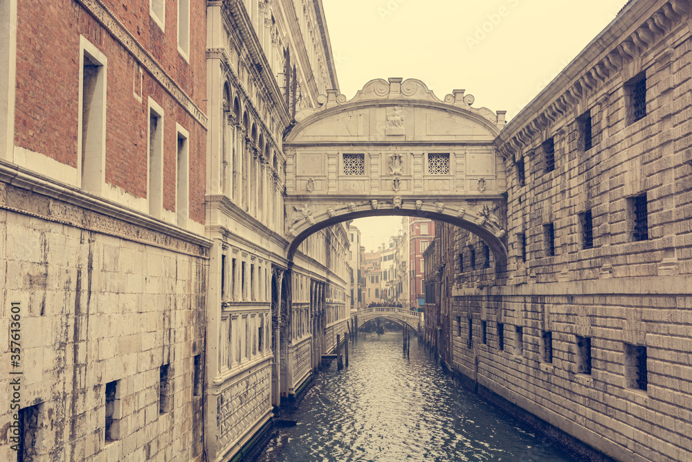 Decorative archway over a canal connecting two buildings.