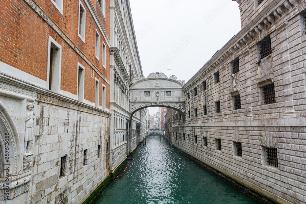 Decorative archway over a canal connecting two buildings.