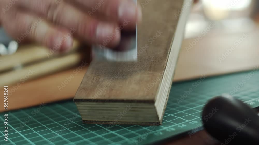 The Tanner sharpens the leather cutter to razor sharpness. Processing of a knife for leather on a polishing cloth The Tanner sharpens the leather cutter to razor sharpness. Processing of a knife for leather on a polishing cloth