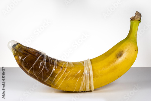 Condom over blackened banana. Concept for sexually transmitted infections, STD, STI