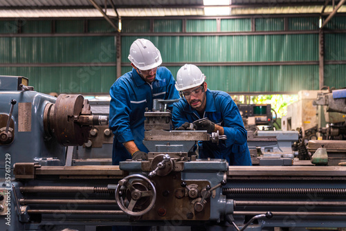 Professional technicians and two engineers are working in industrial plants. Professional technicians and engineers are working in fatory plants that work on steel. Working together.