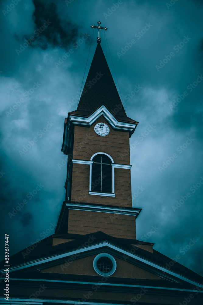Fototapeta premium Catholic Church on the banks of the Tisza River, Rakhiv, Ukraine. Travel photography. Night blue filter.
