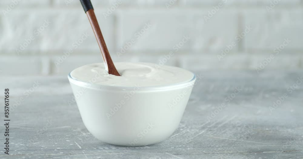 Sour cream in a bowl with a spoon slowly rotates. Sour cream in a bowl with a spoon slowly rotates.