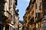 Close up view on the old Italian street with historic traditional houses in Brescia, Lombardy, Italy. European architecture and landmark with wooden windows, shutters, chimneys, tiled roofs.