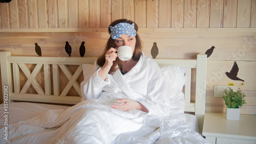 Beautiful woman relaxing in bed drinking coffee at morning