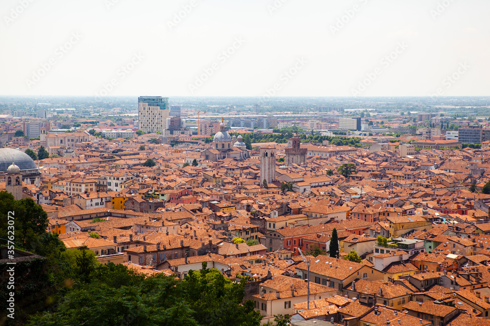 Panoramic, aerial view of the historic center of Brescia, Lombardy, Italy. Traditional medieval Europe with tiled roofs, narrow streets, stone houses, Duomo and Clock tower. Heritage. Architecture.
