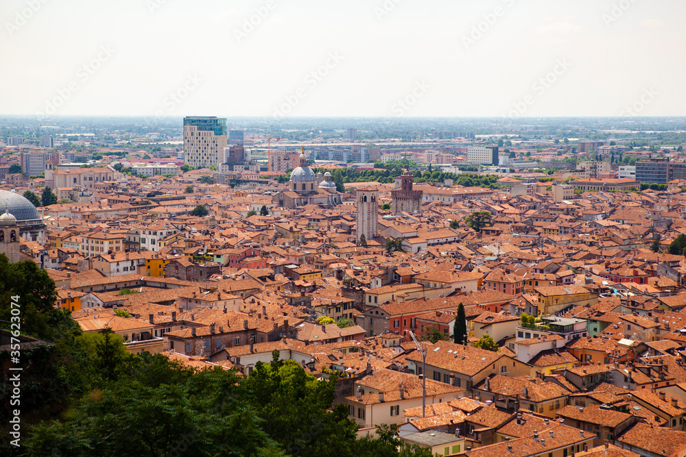 Panoramic, aerial view of the historic centre of Brescia, Lombardy, Italy. Traditional medieval Europe with tiled red roofs, narrow streets, stone houses, Duomo,  Clock tower. Heritage. Architecture.