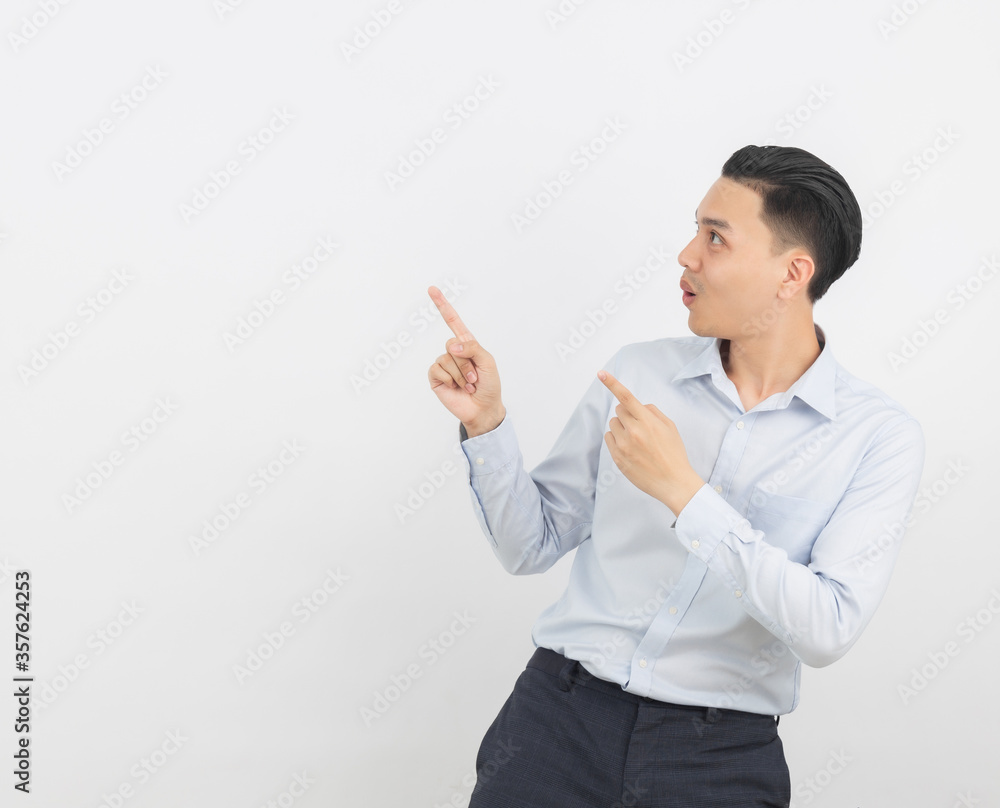 Young asian business man with blue shirt pointing to the side with a hand to present a product or an idea isolated on white background. Young asian business man with blue shirt pointing to the side with a hand to present a product or an idea isolated on white background.