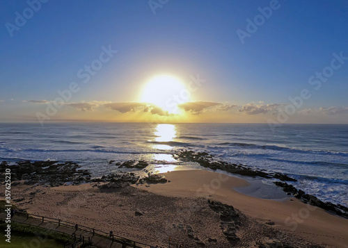 Sunrise  over Ballito beach with horizon clouds