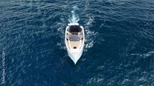 Aerial drone top down photo of small power boat with wooden deck cruising in deep blue Mediterranean sea © aerial-drone