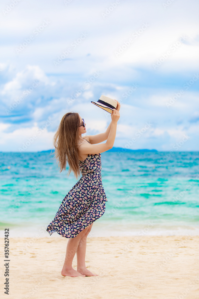 Young beautiful sexy woman relaxing on the white sandy beach near the waves of blue on tropical beach background near ocean / Summer concept Young beautiful sexy woman relaxing on the white sandy beach near the waves of blue on tropical beach background near ocean / Summer concept