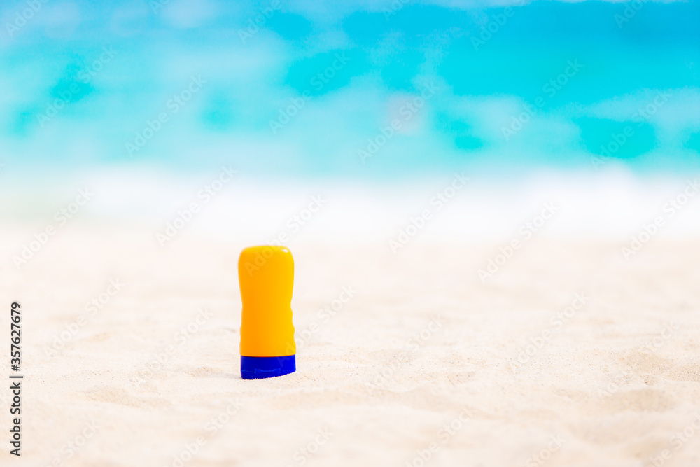 Hand of female holding sunscreen applying sunscreen on her hands from a bottle on the beach with the sea /Health concepts and skin care. Hand of female holding sunscreen applying sunscreen on her hands from a bottle on the beach with the sea /Health concepts and skin care.