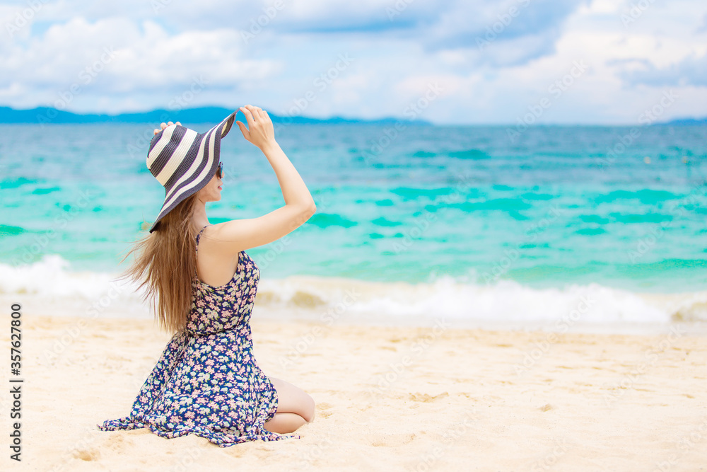 Young beautiful sexy woman relaxing on the white sandy beach near the waves of blue on tropical beach background near ocean / Summer concept Young beautiful sexy woman relaxing on the white sandy beach near the waves of blue on tropical beach background near ocean / Summer concept