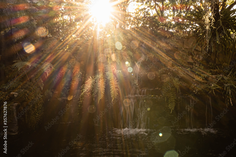 Vintage retro effect filtered hipster style image of tropical waterfall with sun rays. Waterfall with sun rays