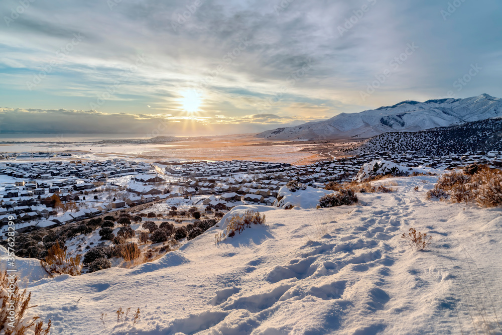 Snowy hill with scenic winter view of homes and lake and mountain in Draper Utah