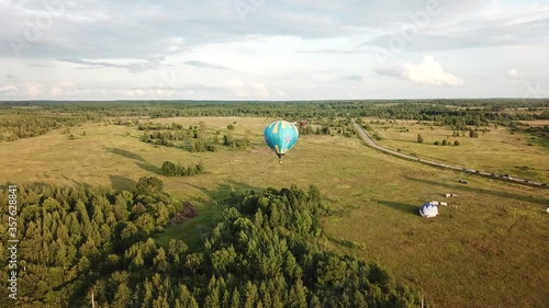 4K quality aerial video of hot air balloons taking off in green fields on cloudy afternoon near town Rostov and Nero Lake in historical medieval Yaroslavl region north-east of Moscow, Russia photo