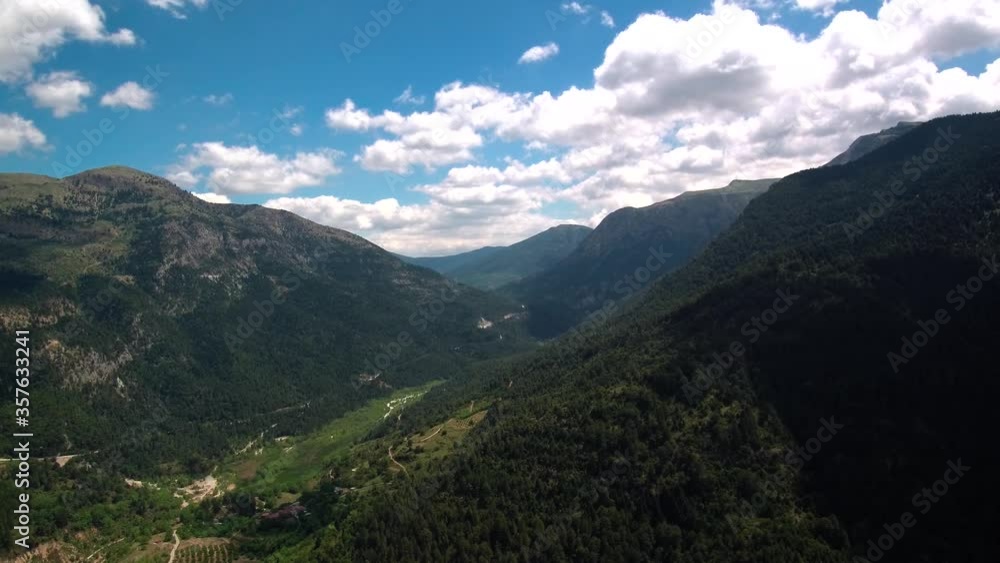 Aerial hyperlapse shot above green hills and mountains with moving clouds on an overcast day. Aerial hyperlapse shot above green hills and mountains with moving clouds on an overcast day.