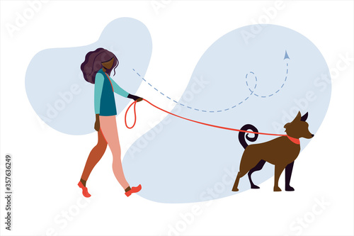 Young african woman walks in the park with a dog. Young African American woman walking a dog on the street
