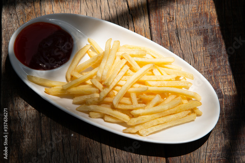 home made french fry on white plate with pepper half ketchup on wood table stock photo