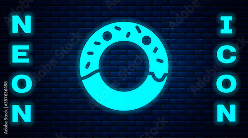 Glowing neon Donut with sweet glaze icon isolated on brick wall background. Vector Illustration.