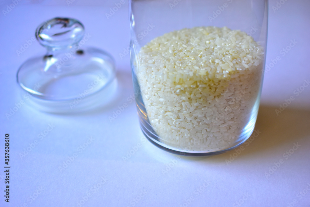 Glass vessel with a lid and white rice inside Glass vessel with a lid and white rice inside