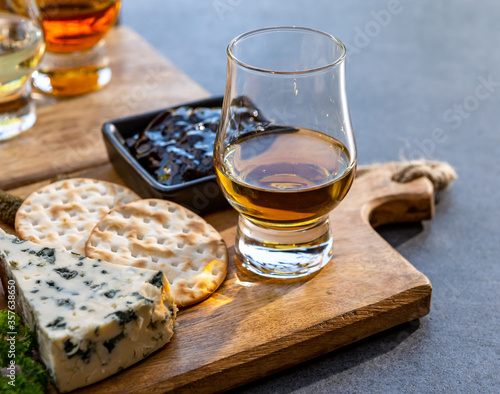 Whiskey and cheese pairing, tasting whisky glasses and plate with sliced cheeses photo