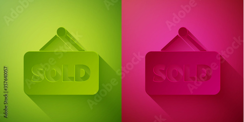 Paper cut Hanging sign with text Sold icon isolated on green and pink background. Sold sticker. Sold signboard. Paper art style. Vector Illustration.