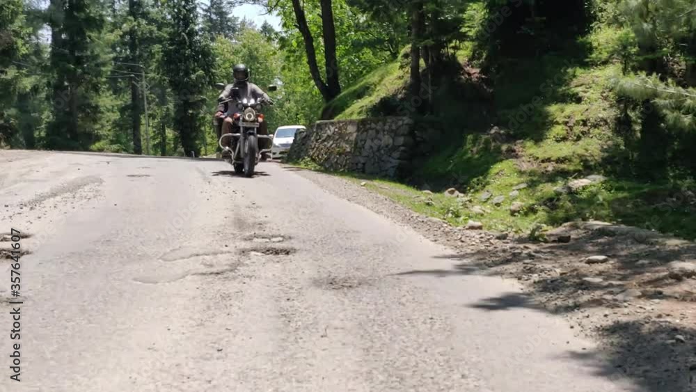 A young motorbike rider riding across the green meadows of Gulmarg, Jammu and Kashmir. A young motorbike rider riding across the green meadows of Gulmarg, Jammu and Kashmir.