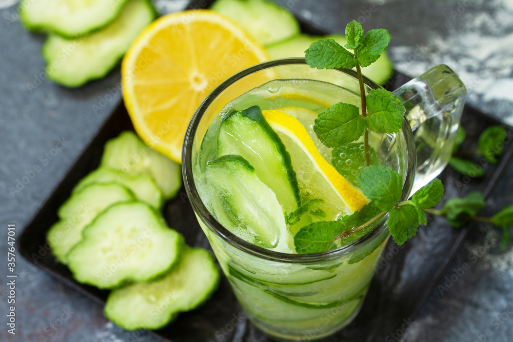 Detox drink close-up. Fresh Cold and refreshing water with lemon and cucumber on a stone table. Detox drink close-up. Fresh Cold and refreshing water with lemon and cucumber on a stone table.