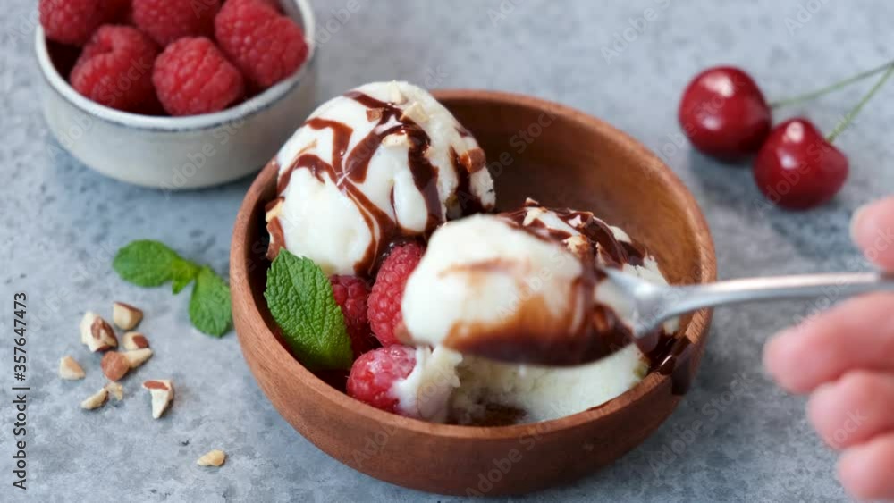 Eating ice cream with a spoon. Taking bite of homemade vegetarian vanilla chocolate ice cream Eating ice cream with a spoon. Taking bite of homemade vegetarian vanilla chocolate ice cream