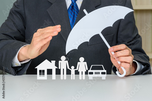 Foto Broker / insurer holds an umbrella to protect parents e