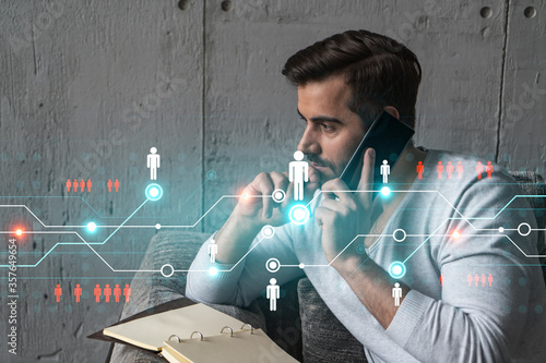 Handsome PR manager in casual wears, speaking phone, taking notes at office try to solve recruitment chalenge from customer. Double exposure. The concept of worldwide hiering in any industry. photo