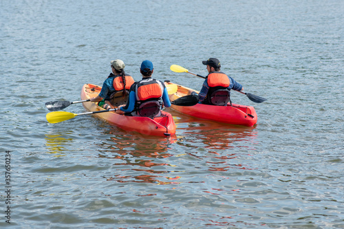 Three kayakers kayak on the Potomac River in Washington, D.C.