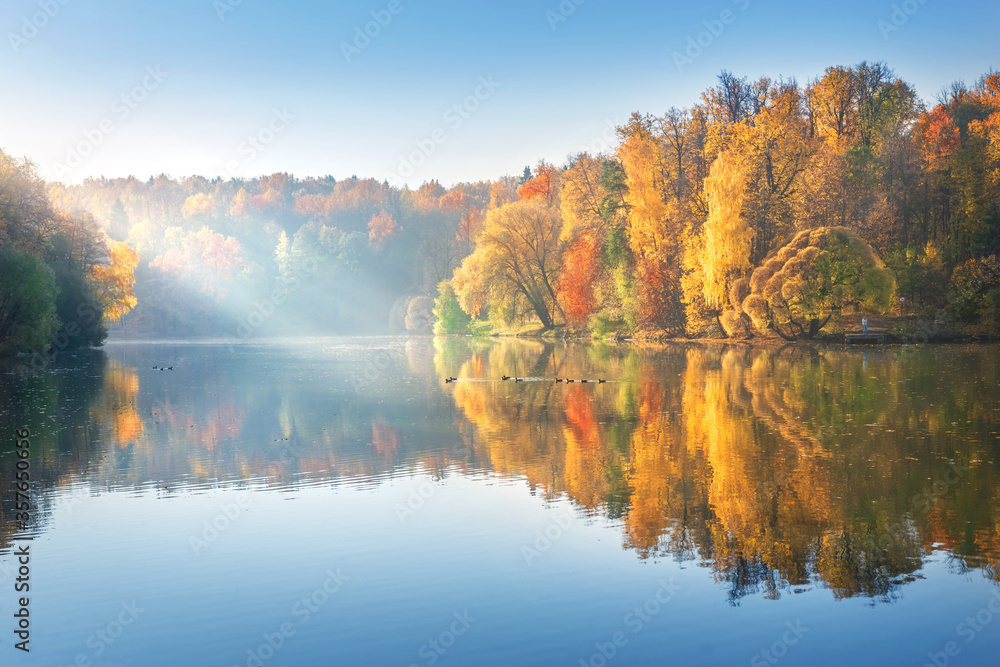 Beautiful autumn landscape of colorful trees with reflection in the pond of Tsaritsyno park in Moscow