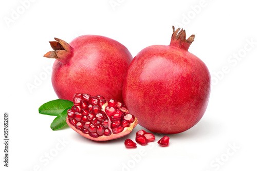 Ripe pomegranate fruits with seed and leaves isolated on the white background.