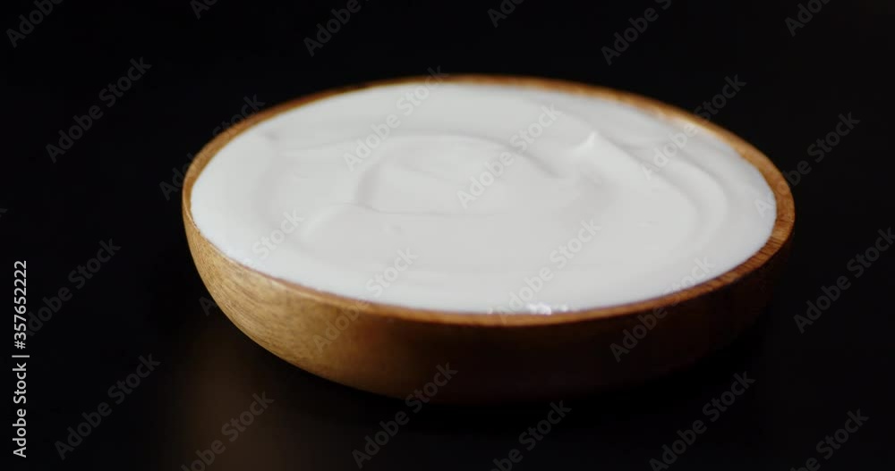 Wooden plate with sour cream slowly rotates on the table. Wooden plate with sour cream slowly rotates on the table.