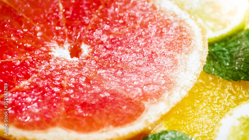 Macro image of sugar dissolving on fresh juice grapefruit slice on white background