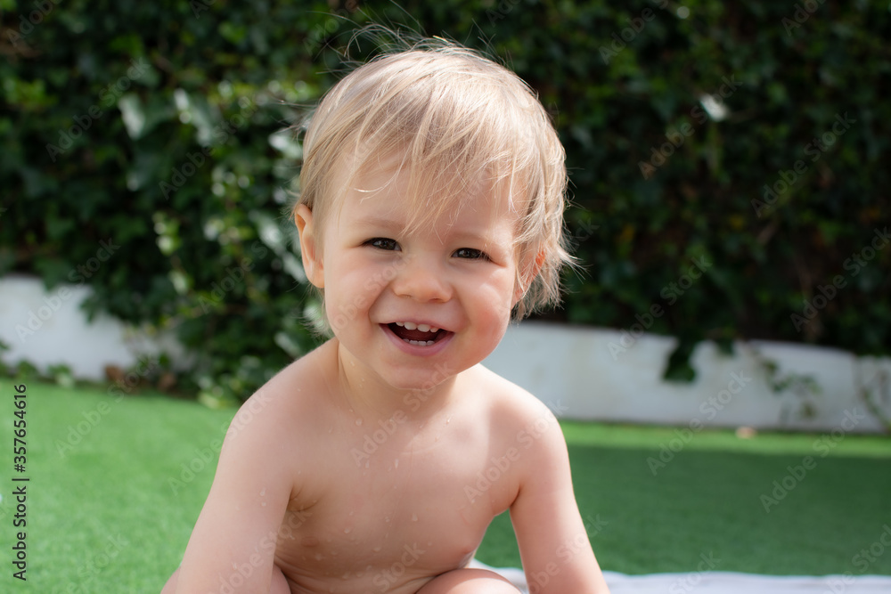 Beautiful blond baby very happy and smiling in the pool Beautiful blond baby very happy and smiling in the pool