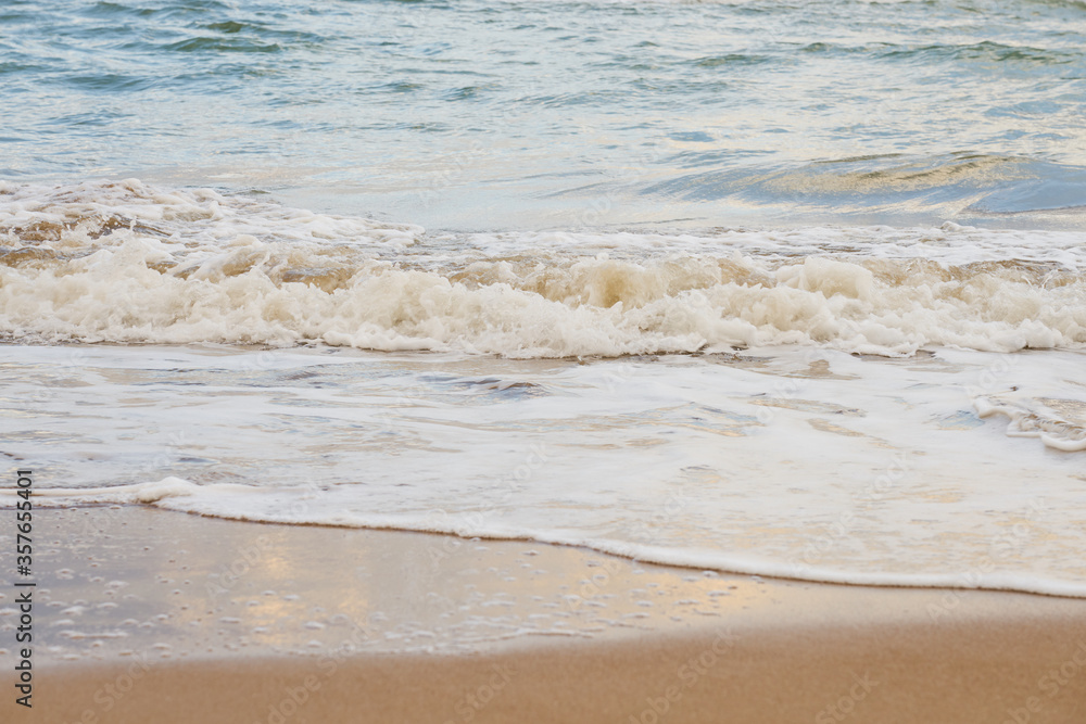 Sandy beach on a sunset with reflection on wet sand and waves with foam. Copy space. Sandy beach on a sunset with reflection on wet sand and waves with foam. Copy space.