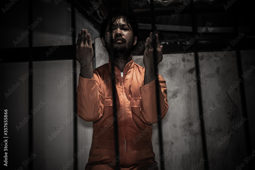 Asian man desperate at the iron prison,prisoner concept,thailand people,Hope to be free,Serious prisoners imprisoned in the prison,Prayer to god