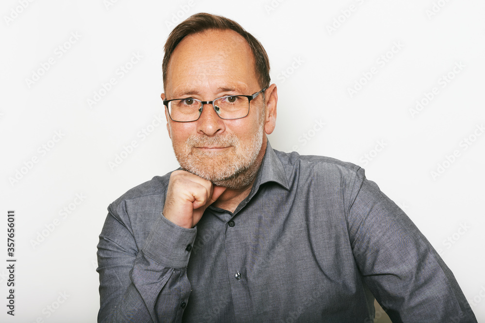 Close up portrait of middle age man taken on white background, wearing grey shirt and glasses Close up portrait of middle age man taken on white background, wearing grey shirt and glasses