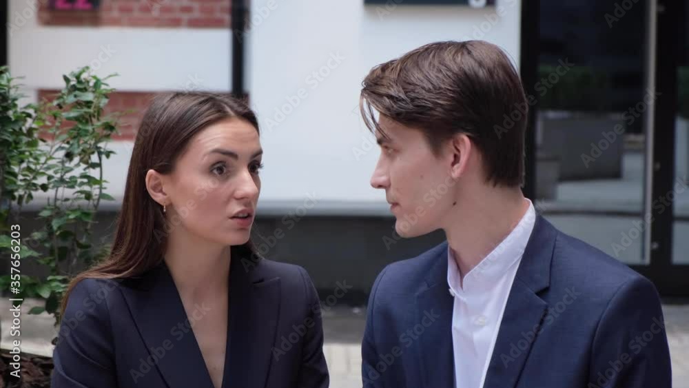 a young couple sit on a bench and communicate a young couple sit on a bench and communicate